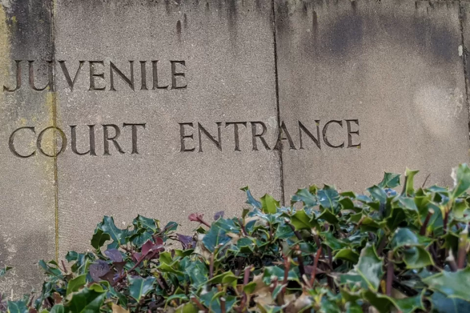 Weathered stone slabs with the words Juvenile Court Entrance engraved into it.